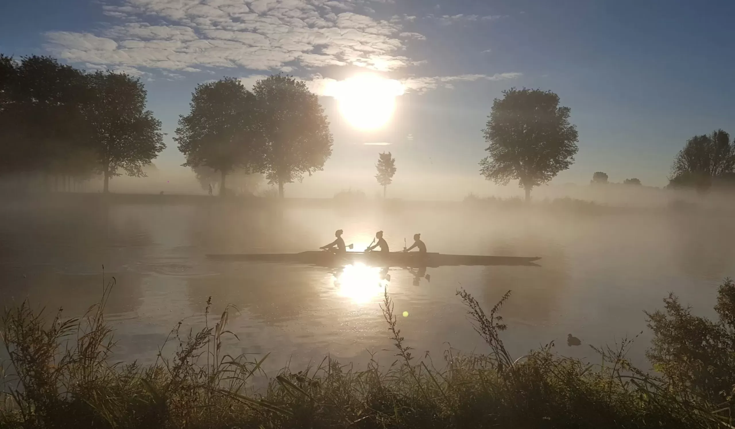 Ochtend-roeiers in de Amstel onder dauw. 